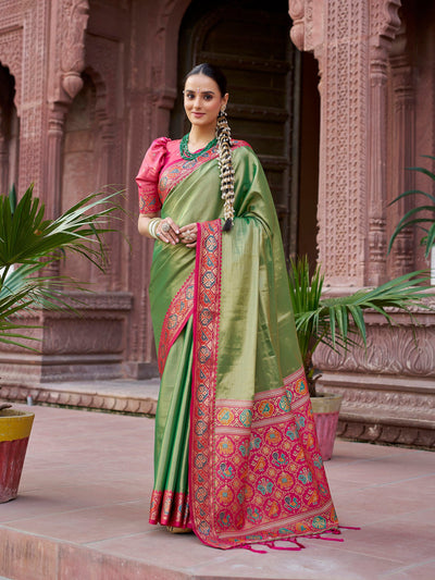 Tan Green Solid Zari Tissue Jacquard Banarasi Saree by Elora, crafted in premium silk with shimmering zari detailing and intricate jacquard weaving. This elegant Banarasi saree blends traditional charm and modern grace, ideal for festive wear, weddings, and special cultural occasions with a luxurious designer finish.